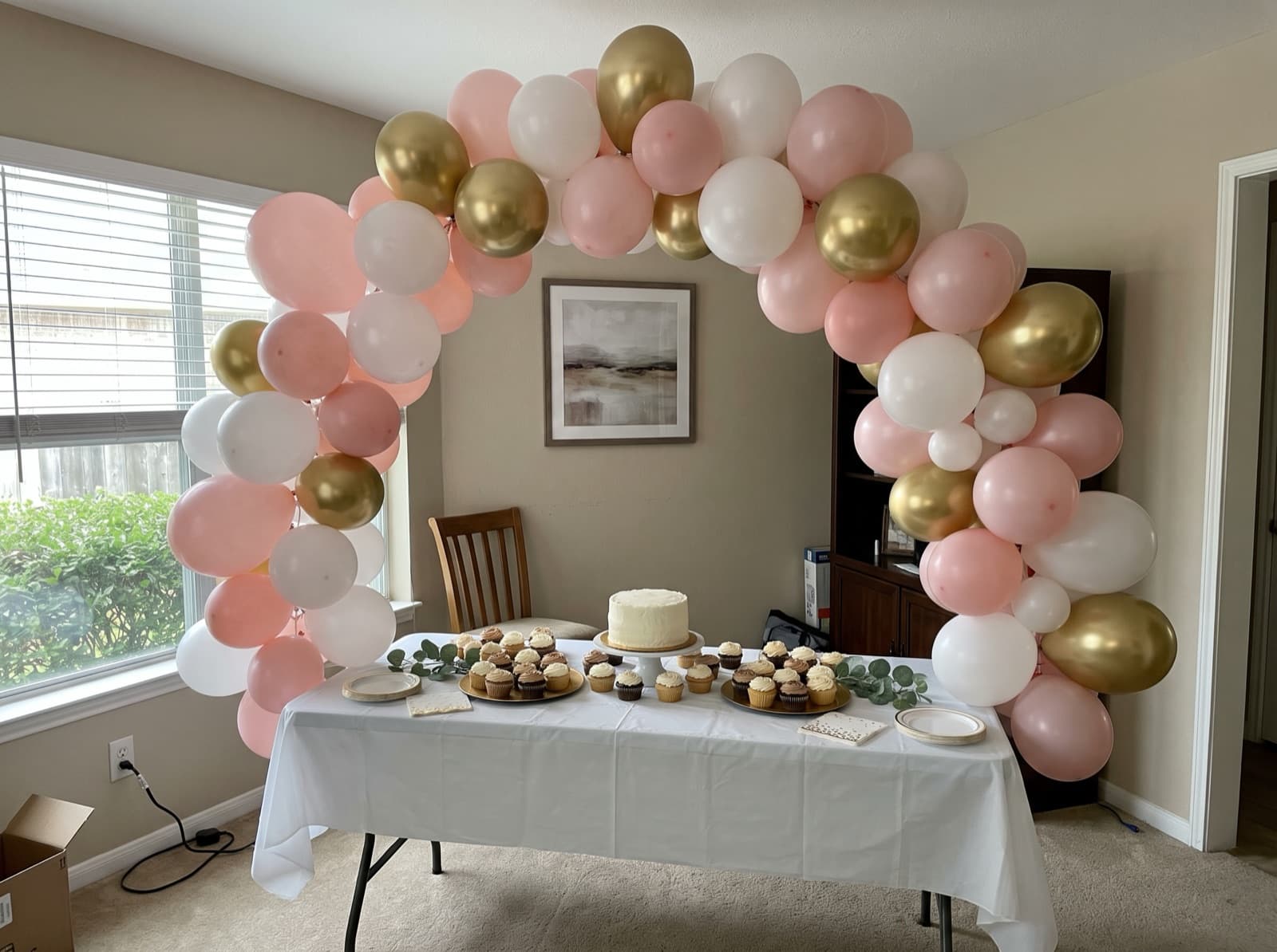 Organic balloon arch in blush, white and gold over a dessert table